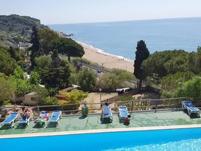 a swimming pool with a view of a beach at Apartment Beach Front Sant Pol in San Pol de Mar