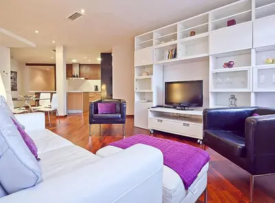 a living room with a white couch and a tv at Ciutadella Park Born in Barcelona