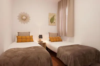a bedroom with two beds and a mirror on the wall at Click&Flat Europa Fira Apartments in Hospitalet de Llobregat