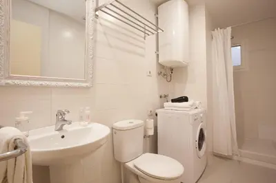 a white bathroom with a toilet and a sink at Click&Flat Europa Fira Apartments in Hospitalet de Llobregat