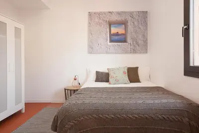 a bedroom with a bed and a picture on the wall at Click&Flat Europa Fira Apartments in Hospitalet de Llobregat