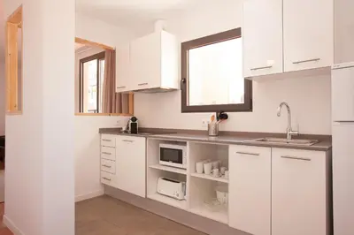 a kitchen with white cabinets and a sink at Click&Flat Europa Fira Apartments in Hospitalet de Llobregat