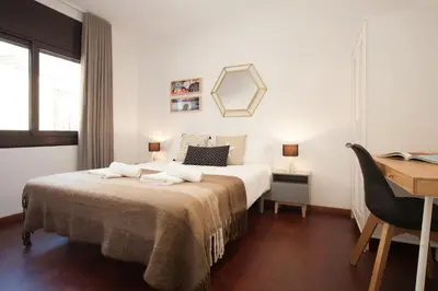 a white bedroom with a bed and a desk and a desk at Click&Flat Europa Fira Apartments in Hospitalet de Llobregat