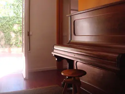 a piano with a stool next to a window at Suitur Courtyard Apartment in Barcelona