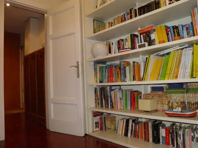 a book shelf filled with lots of books at Suitur Courtyard Apartment in Barcelona