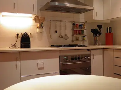 a kitchen with white cabinets and a stove top oven at Suitur Courtyard Apartment in Barcelona