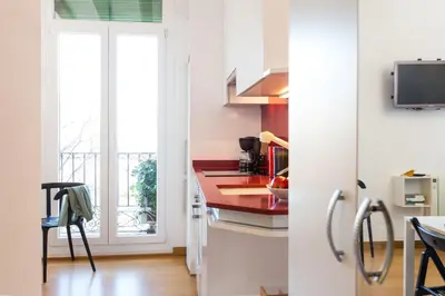 a kitchen with white cabinets and a red counter top at Casa Cosi Sant Antoni in Barcelona
