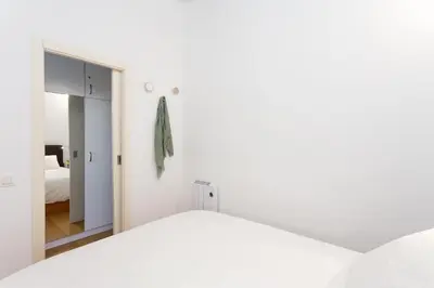 a bedroom with a white bed and a mirror at Casa Cosi Sant Antoni in Barcelona