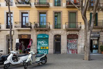 two scooters parked in front of a building with graffiti at Casa Cosi Sant Antoni in Barcelona