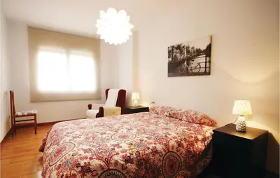 a bedroom with a bed and a chandelier at Gorgeous Apartment In Pineda De Mar in Pineda de Mar