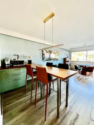 a kitchen and dining room with a wooden table and chairs at La Marina de Aiguadolç in Sitges