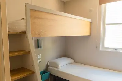a small room with a bunk bed and a window at Camping Sènia Caballo de Mar in Pineda de Mar
