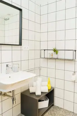 a white bathroom with a sink and a mirror at BYPILLOW Wander in Barcelona