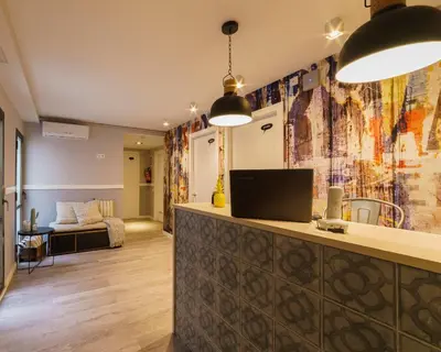a living room with a counter and a living room with a couch at BYPILLOW Wander in Barcelona