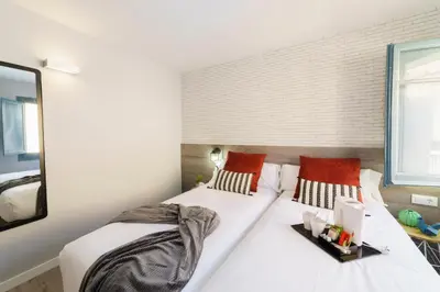 a bedroom with a large white bed with red pillows at BYPILLOW Wander in Barcelona