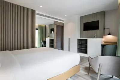 a bedroom with a large white bed and a desk at Niu Barcelona Hotel in Barcelona