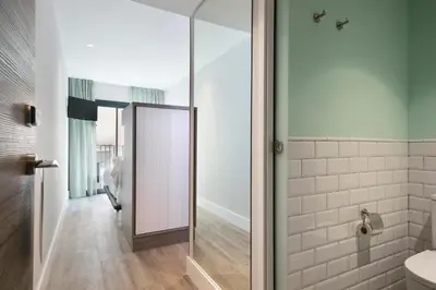 a bathroom with a glass shower door and a toilet at Niu Barcelona Hotel in Barcelona