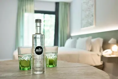 a bottle of alcohol and two glasses on a table at Niu Barcelona Hotel in Barcelona