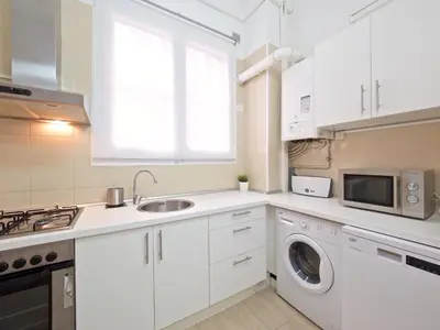 a white kitchen with a sink and a washing machine at Suites4days Gaudi Eixample in Barcelona