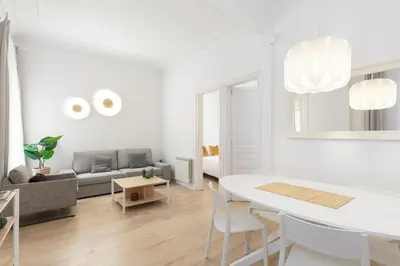 a white living room with a table and a couch at Suites4days Gaudi Eixample in Barcelona