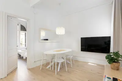 a white dining room with a white table and chairs at Suites4days Gaudi Eixample in Barcelona