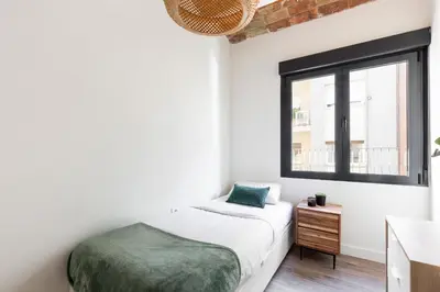 a white bedroom with a bed and a window at Modern Catalan Apartments by Olala Homes in Hospitalet de Llobregat