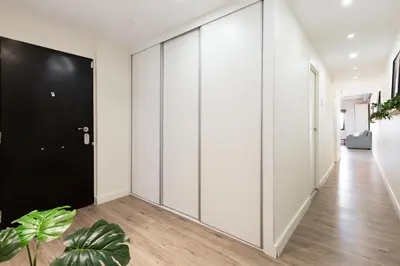 a hallway with white walls and a black door at Modern Catalan Apartments by Olala Homes in Hospitalet de Llobregat