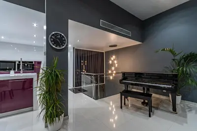 a living room with a piano and a clock at Luxurious Villa Marly I to two minutes the beach in Castelldefels
