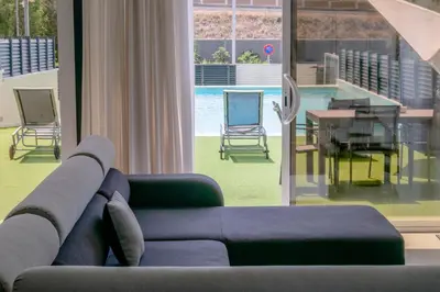 a living room with a couch and a table and chairs at Luxurious Villa Marly I to two minutes the beach in Castelldefels
