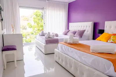 two beds in a room with purple walls at Luxurious Villa Marly I to two minutes the beach in Castelldefels