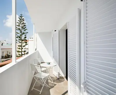 a white balcony with a table and chairs on it at Destino Sitges in Sitges
