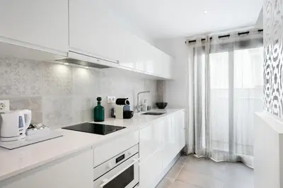 a white kitchen with white appliances and a window at Destino Sitges in Sitges