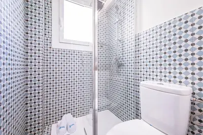 a bathroom with a shower with a toilet and a window at Sweett - Atic Eloi in Barcelona
