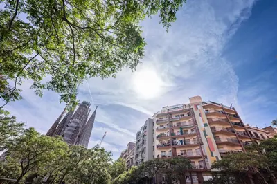 a tall apartment building with the sun in the sky at Sweett - Atic Eloi in Barcelona