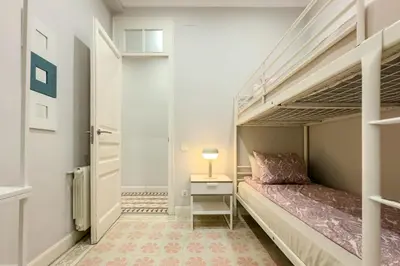 a small bedroom with a bunk bed and a lamp at Novus Homes Barcelona Eixample in Barcelona