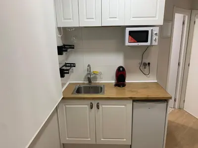 a small kitchen with a sink and a microwave at Plaza de España independent house in Barcelona