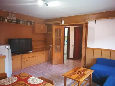 a living room with a blue couch and a tv at Holidays Domus Iano in Esparreguera