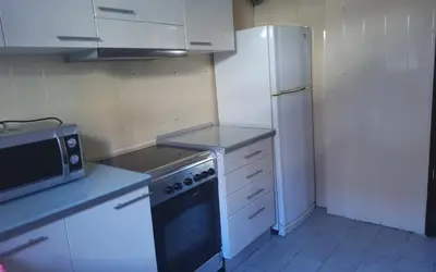 a kitchen with a white refrigerator and a stove at Holidays Domus Iano in Esparreguera