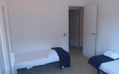 a small room with two beds and a hallway at Holidays Domus Iano in Esparreguera