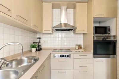 a white kitchen with a sink and a stove at Ola Living Merce in Barcelona