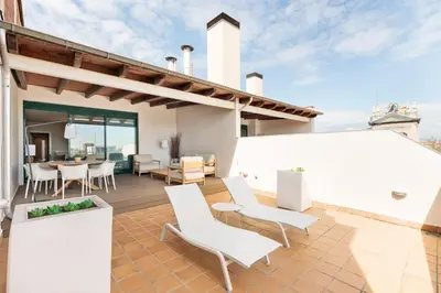 a patio of a house with white chairs and a table at Ola Living Merce in Barcelona