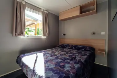 a bedroom with a bed in a room with a window at Camping El Pasqualet in Caldes de Montbui