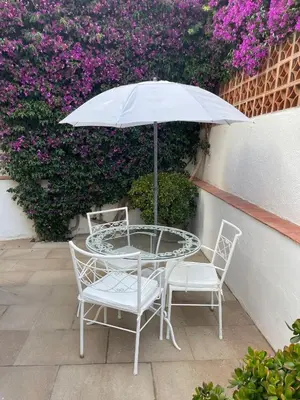 a table and chairs with an umbrella and flowers at Studio Relax by Hello Homes Sitges in Sitges
