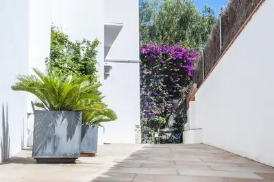 a courtyard with potted plants on a white wall at Studio Relax by Hello Homes Sitges in Sitges