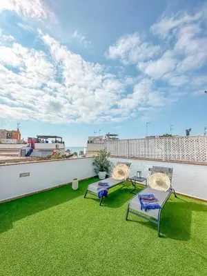 a patio with two chairs and a table on a roof at Sanctuary Penthouse by Hello Homes Sitges in Sitges
