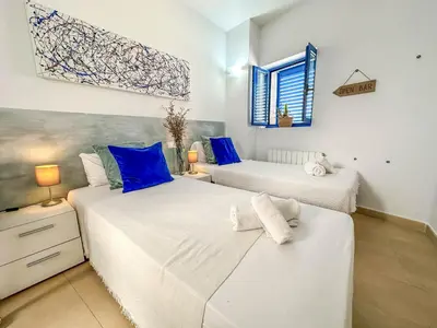 two beds in a room with blue and white at Sanctuary Penthouse by Hello Homes Sitges in Sitges