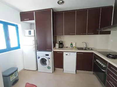 a kitchen with a washing machine and a washer at Sanctuary Penthouse by Hello Homes Sitges in Sitges