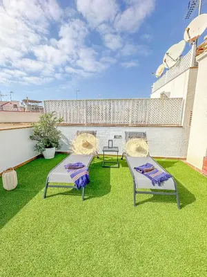 two chairs sitting on the grass on a balcony at Sanctuary Penthouse by Hello Homes Sitges in Sitges