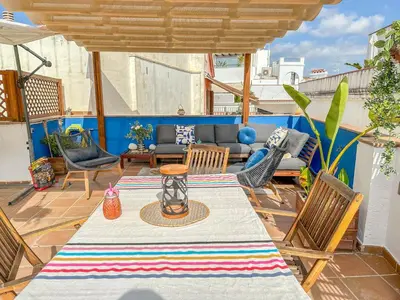 a patio with a table and chairs and a couch at Sanctuary Penthouse by Hello Homes Sitges in Sitges