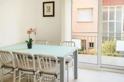 a dining room with a white table and chairs at Next to the sea 20' from Barcelona in Premiá de Mar